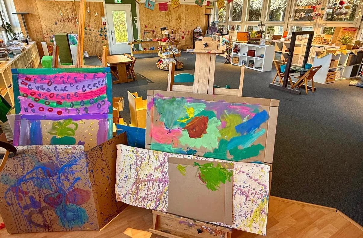Children's paintings drying on easels in the project area