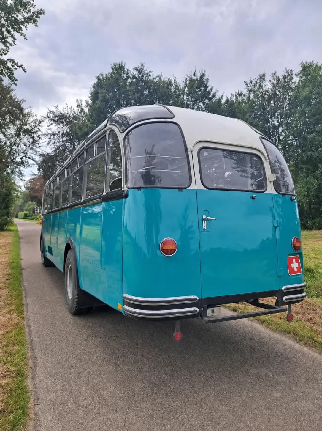 Der Schweizer Montessori-Schulbus von hinten auf einem Waldweg