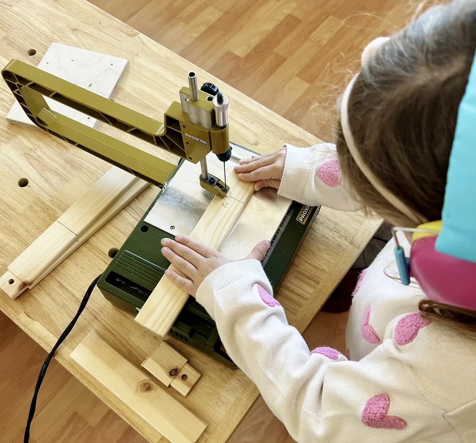 A child using a scroll saw in the Trinity woodworking room