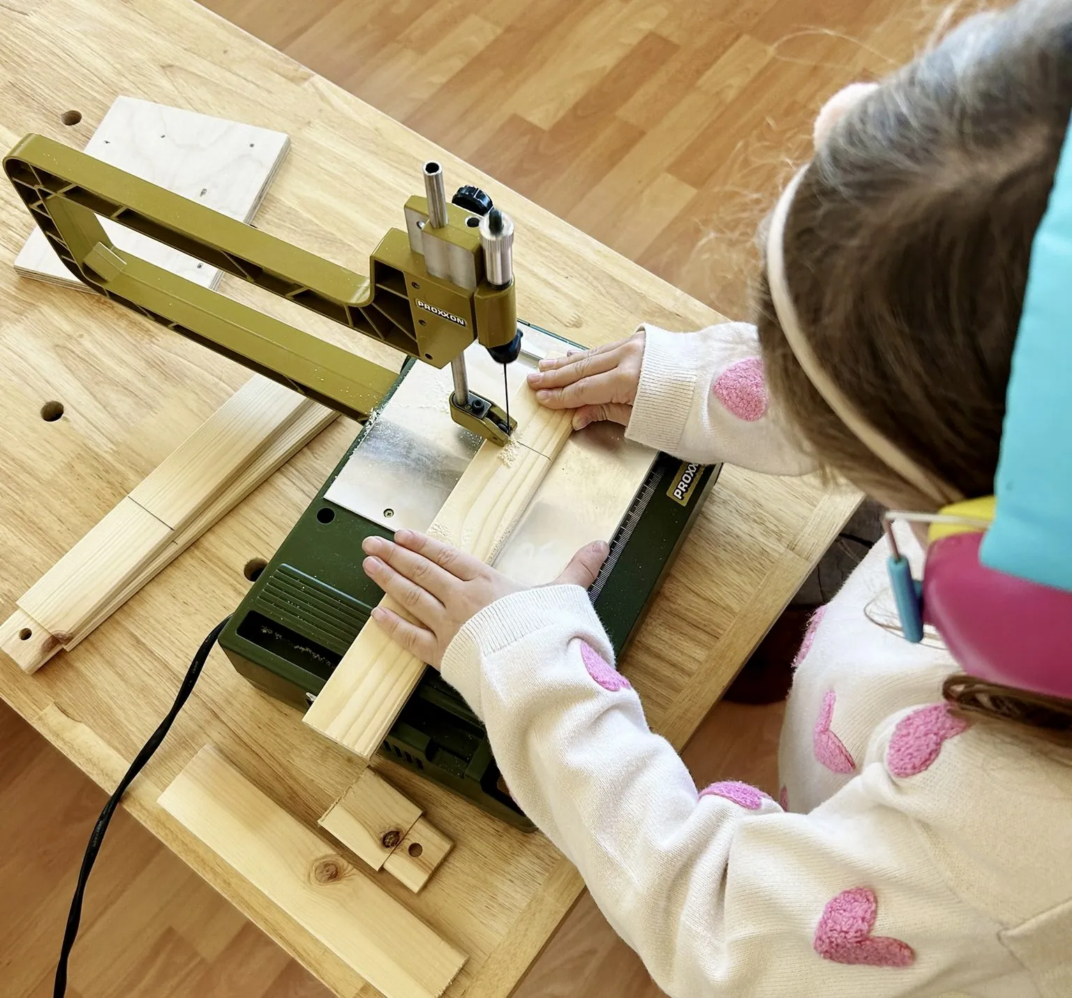 Ein Kind an der Laubsäge in der Holzwerkstatt von Trinity